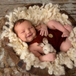 Newborn baby smiling during photo session in Wishart