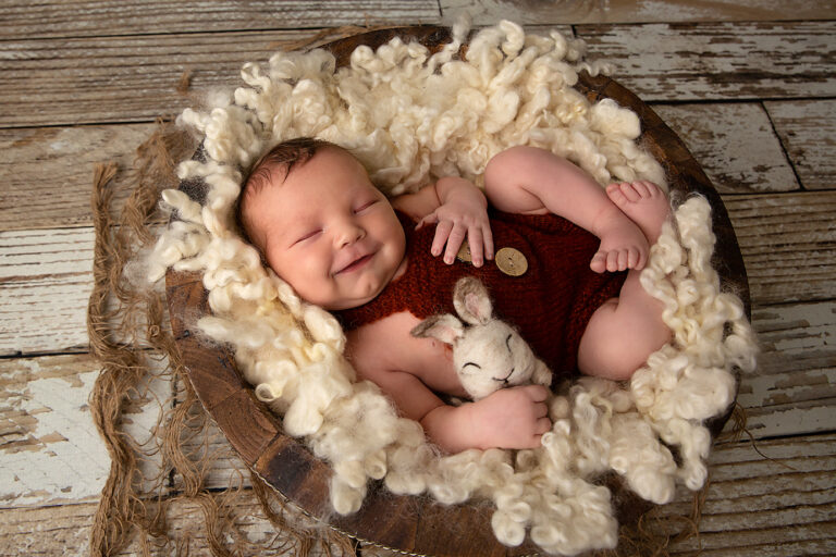 Newborn baby smiling during photo session in Wishart