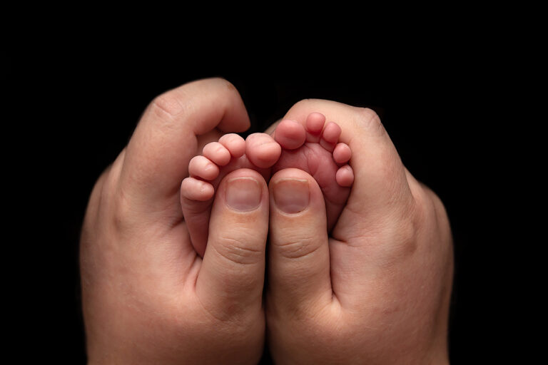 Tiny newborn hands held by parent - Brisbane newborn photography